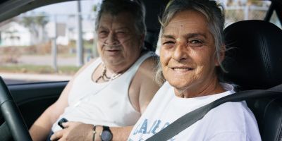 Photo of a woman and a man in a car smiling