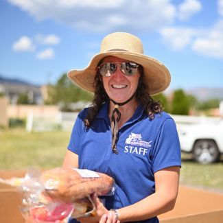 A food bank staff member holding bread.
