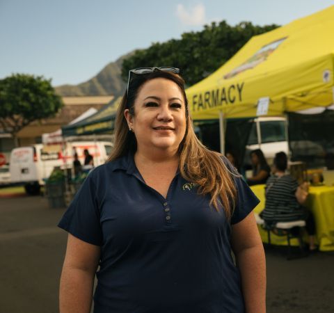 A woman standing in front of a pharmacy tent.