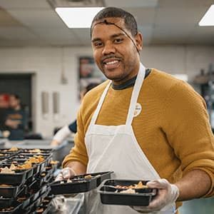 A man holding two plates of food.