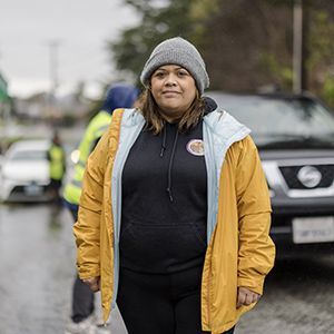 A woman wearing a jacket while standing outside.