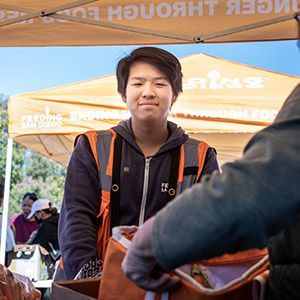 A teenager at an outdoor food distribution tent.