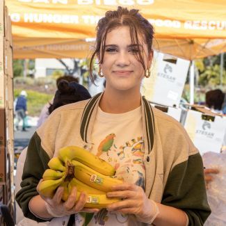 A volunteer standing in a food distribution tent.