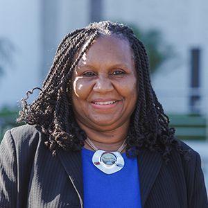 A woman wearing professional attire smiling.