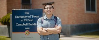 A college student standing in front of a college building.